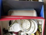 a blue box filled with dishes and cups on a table