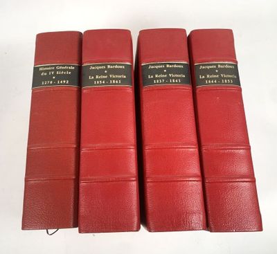 Quatre livres rouges à la reliure noire sont alignés sur une surface blanche