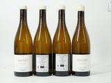 quatre bouteilles de vin sont alignées sur une surface blanche