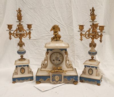 three clocks and three candeliers sitting on a table
