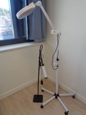 une lampe posée sur un trépied dans une pièce