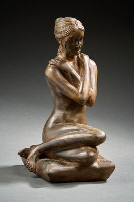 l'image d'une statue de bronze représentant une femme assise sur un rocher