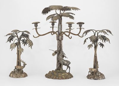 three metal candelabs with palm trees and animals on them