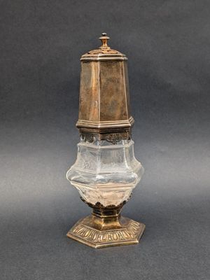 an antique brass and cut glass vase with a lid on a pedestal