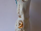 a small white vase with a gold decoration on it