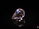 gros plan d'un diamant rose sur une surface noire