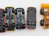 four toy cars sitting next to each other on a white surface