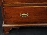 a wooden chest of drawers with a clock on top of it