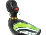 a black duck with a green body and a red lip
