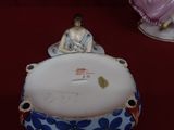 une figurine représentant une femme assise sur un bol
