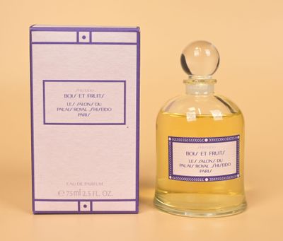 perfume bottle and box of perfume sitting on a yellow surface