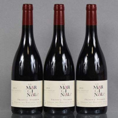 trois bouteilles de vin sont alignées sur une table