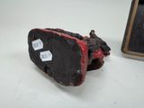 a black and red shoe sitting on a table next to a picture frame