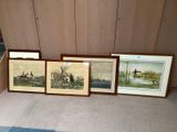 three framed pictures on the floor of a living room