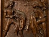 bronze relief of a man and a woman fighting with a goat