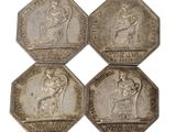 four silver coins with the image of a woman and a man on them