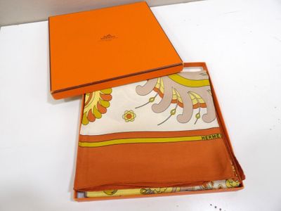 une boîte orange sur laquelle est posé un foulard blanc et jaune