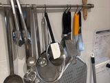 a kitchen with a lot of utensils hanging on the wall