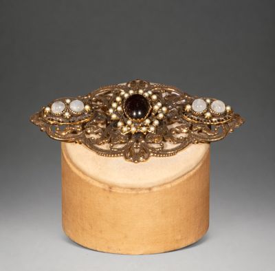 a close up of a wooden box with a broochet on it