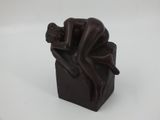 figurine of a man sitting on a box with his head resting on his hands