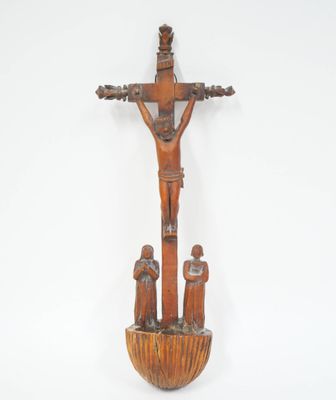un vieux crucifix en bois représentant un homme sur la croix et deux enfants