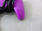 a purple blow dryer sitting on the floor next to a black cord