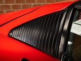 a red sports car parked in front of a brick wall