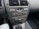 tableau de bord d'une voiture avec le pied d'une personne posé sur le volant