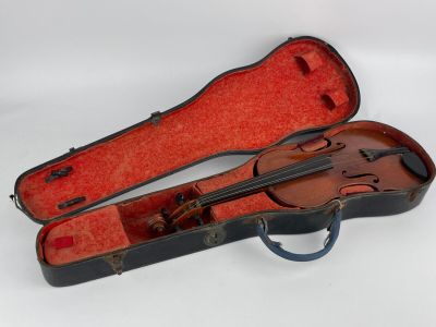 un violon dans son étui, posé sur une surface blanche