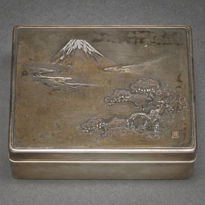 a silver box with a picture of a mountain in the background