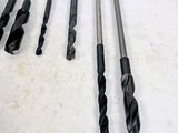 four different types of drill bits are lined up on a table