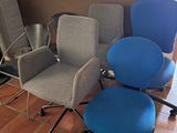 three office chairs are lined up in a row in front of a window