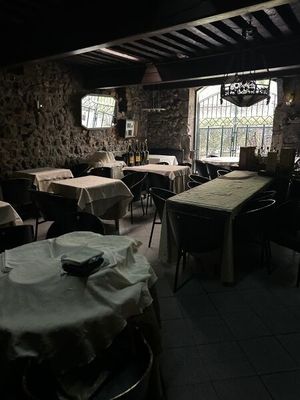 tables and chairs in a restaurant with a stone wall