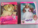 two boxes of barbie dolls are sitting on a table