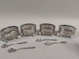 quatre assiettes et cuillères plaquées argent sur un fond blanc