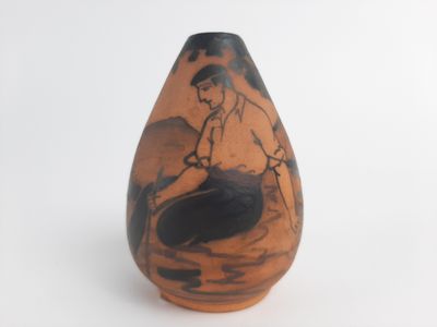 a small vase with a picture of a man sitting on a boat