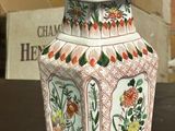 two vases sitting on a table with a brick wall in the background