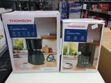 deux cartons contenant des machines à café posés sur une table