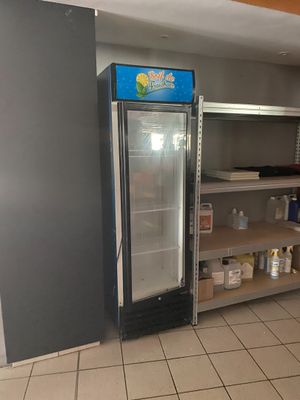 une photo d'une cuisine avec un réfrigérateur et des étagères