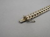a close up of a silver chain with a clasp on a gray surface
