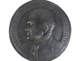 a black and white photo of a medal with a man ' s face on it