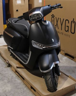 un scooter posé sur un carton dans un entrepôt