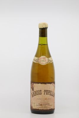 une vieille bouteille de vin posée sur une table blanche
