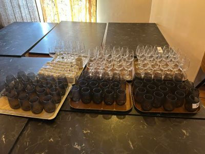 several trays of wine glasses are lined up on a table