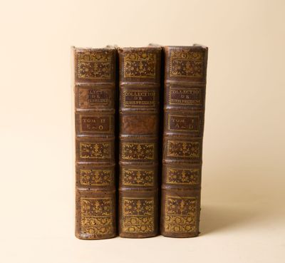 trois vieux livres posés l'un sur l'autre sur une table