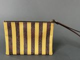 a brown and yellow striped purse on a gray surface
