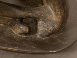a bronze statue of a cat on a plate