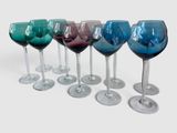 six verres à vin sont alignés sur une surface blanche