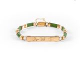 un bracelet doré et vert orné d'une barre gravée