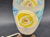 a glass vase with a flower inside of it on a stand